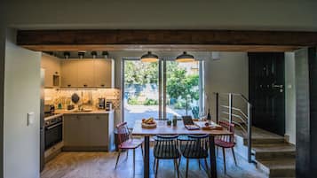 A kitchen with a dining area, a staircase, and a view of the outdoors.