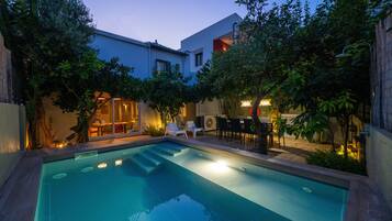 A swimming pool with steps leading into it, surrounded by outdoor seating and plants.