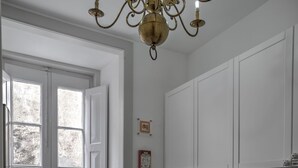 A kitchen with white cabinets, a wooden countertop, a stainless steel sink, and a chandelier.