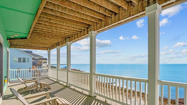 A wooden deck with white railings overlooking a beach. - Premier Soundfront Dog Friendly Oasis w/ Pool, Hot Tub, Elevator, and Much More! (Avon)