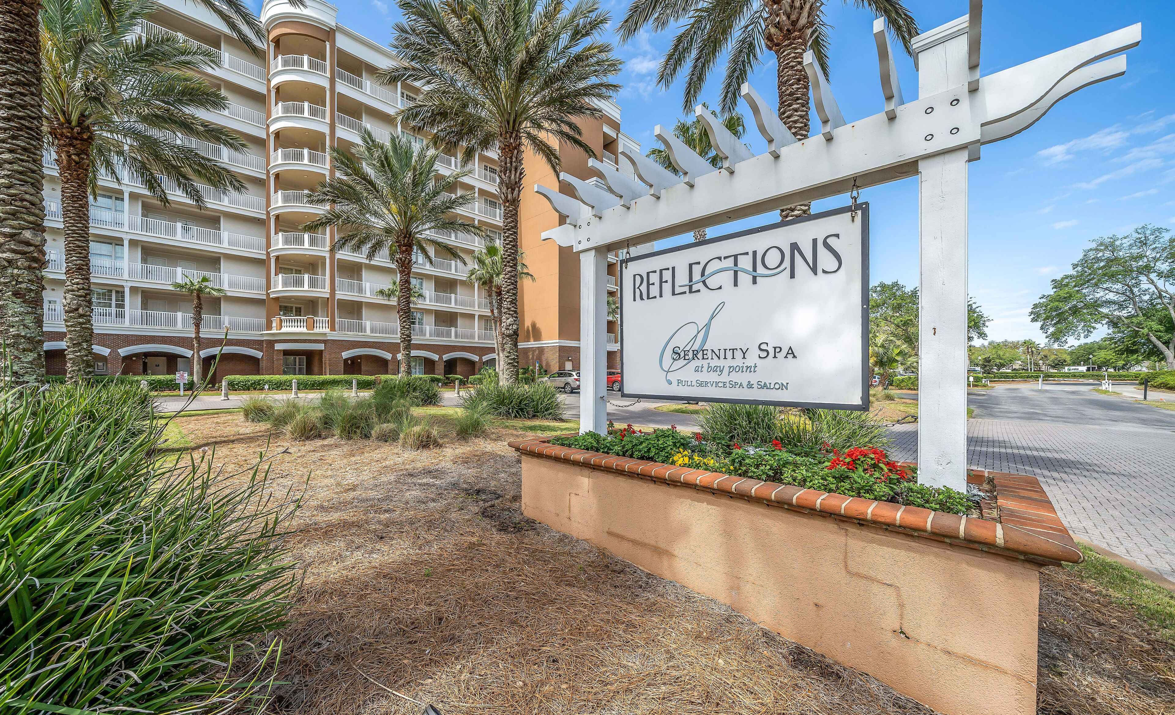 Une enseigne pour le spa Reflections Serenity, situé à Bay Point, représentant un immeuble à plusieurs étages doté de balcons et bordé de palmiers.