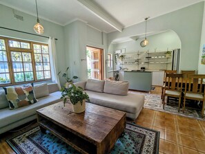 Un salon avec un canapé, une table basse et une vue sur la cuisine.