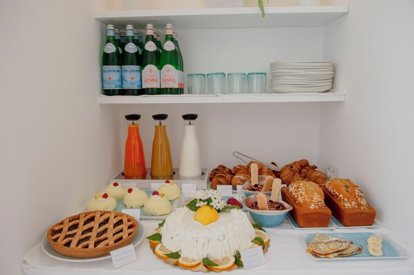 Un bufé con diferentes opciones de comida, como tartas, pasteles y un pastel.