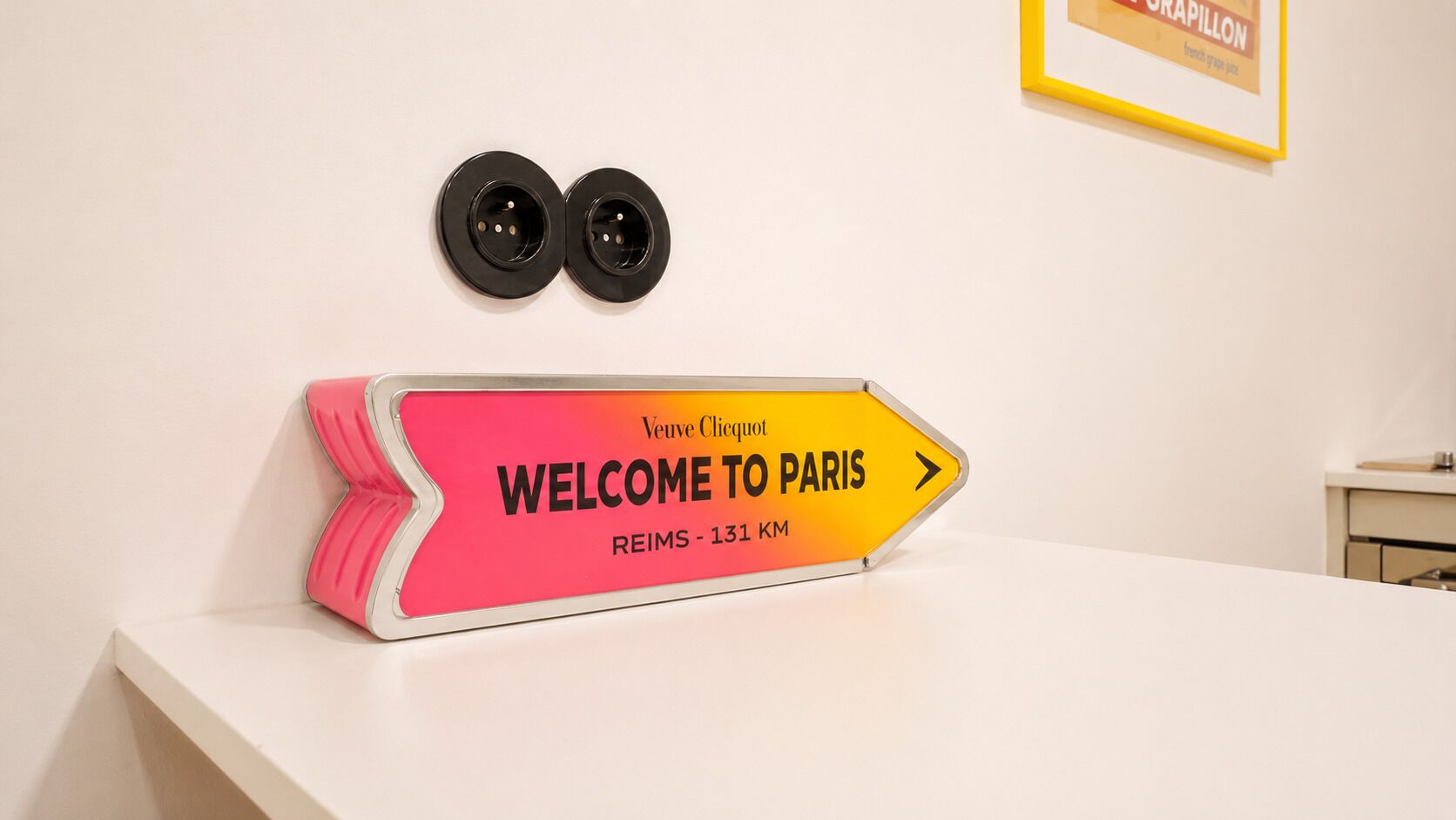 Un panneau de signalisation indiquant la direction, avec les inscriptions « BIENVENUE À PARIS » et « REIMS - 131 KM ».