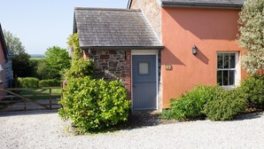 A two-story house with a stone facade and a red exterior. - The Dairy, shared hot tub and sauna (Hartland)
