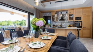 A modern kitchen with wooden cabinets, a central island, and pendant lighting.