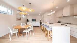 A modern kitchen with a central island, white cabinetry, and pendant lighting.