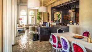 A spacious living area with a large sofa, a dining table with chairs, and a kitchen area with a bar. - Villa Tounsi - Five Bedroom Villa, Sleeps 10 (Douar Tounsi)
