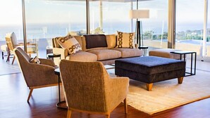 Una sala de estar moderna con un sofá grande, sillones y una mesa de centro.