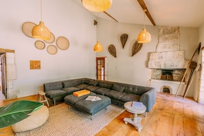 A cozy living room with a sectional sofa, a small round table, and a fireplace.