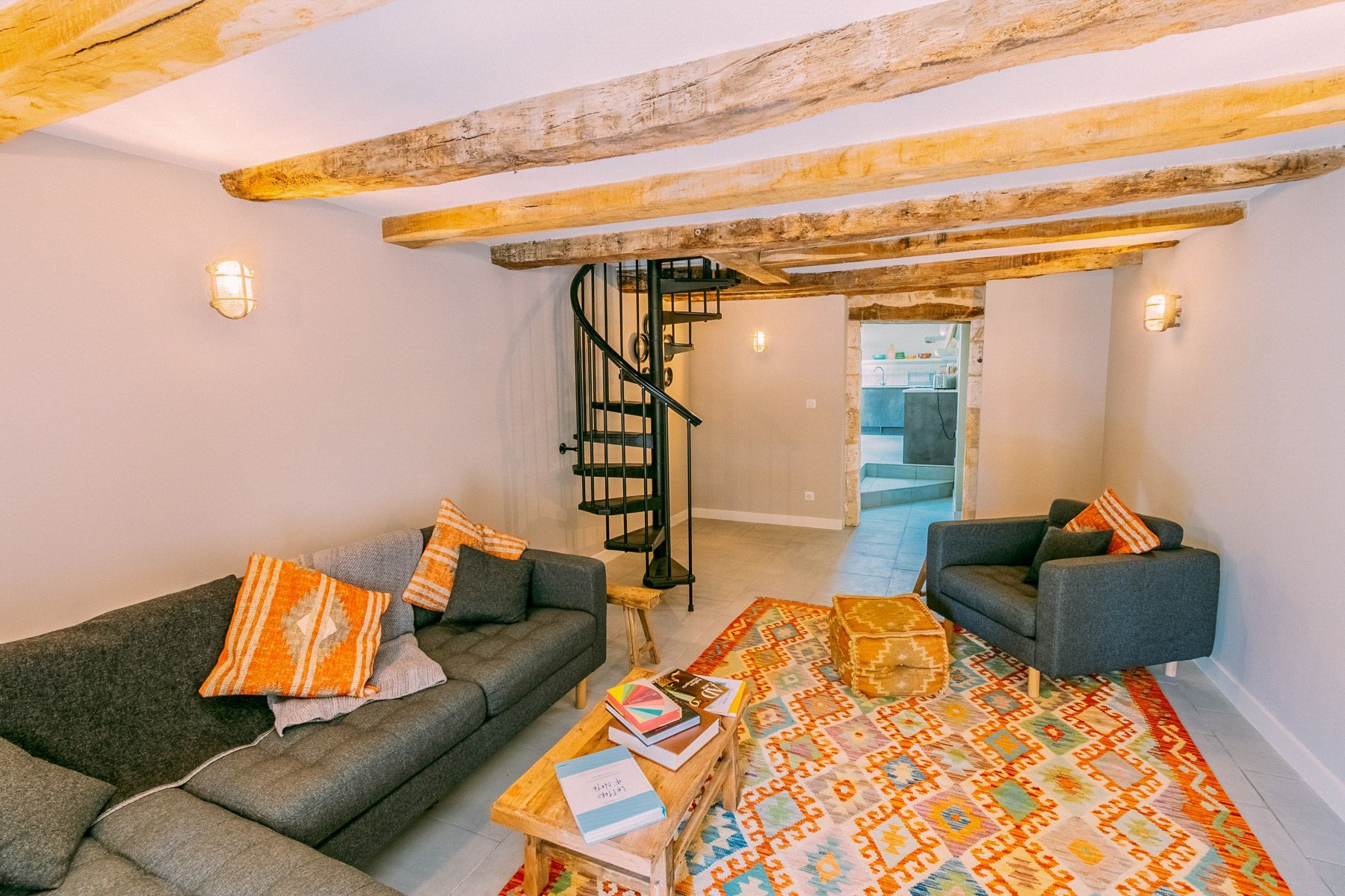 Una sala de estar acogedora con dos sofás, un tapete estampado y una mesa de centro de madera.