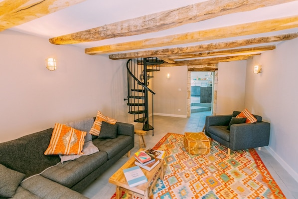 A cozy living room with two sofas, a patterned rug, and a wooden coffee table.