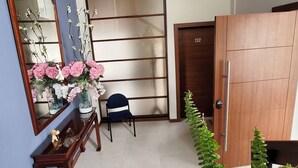 A room with a wooden door marked '202', a mirror with flowers, a chair, and a plant. - Suite moderna 301. La Mejor Ubicación

 (Quito)