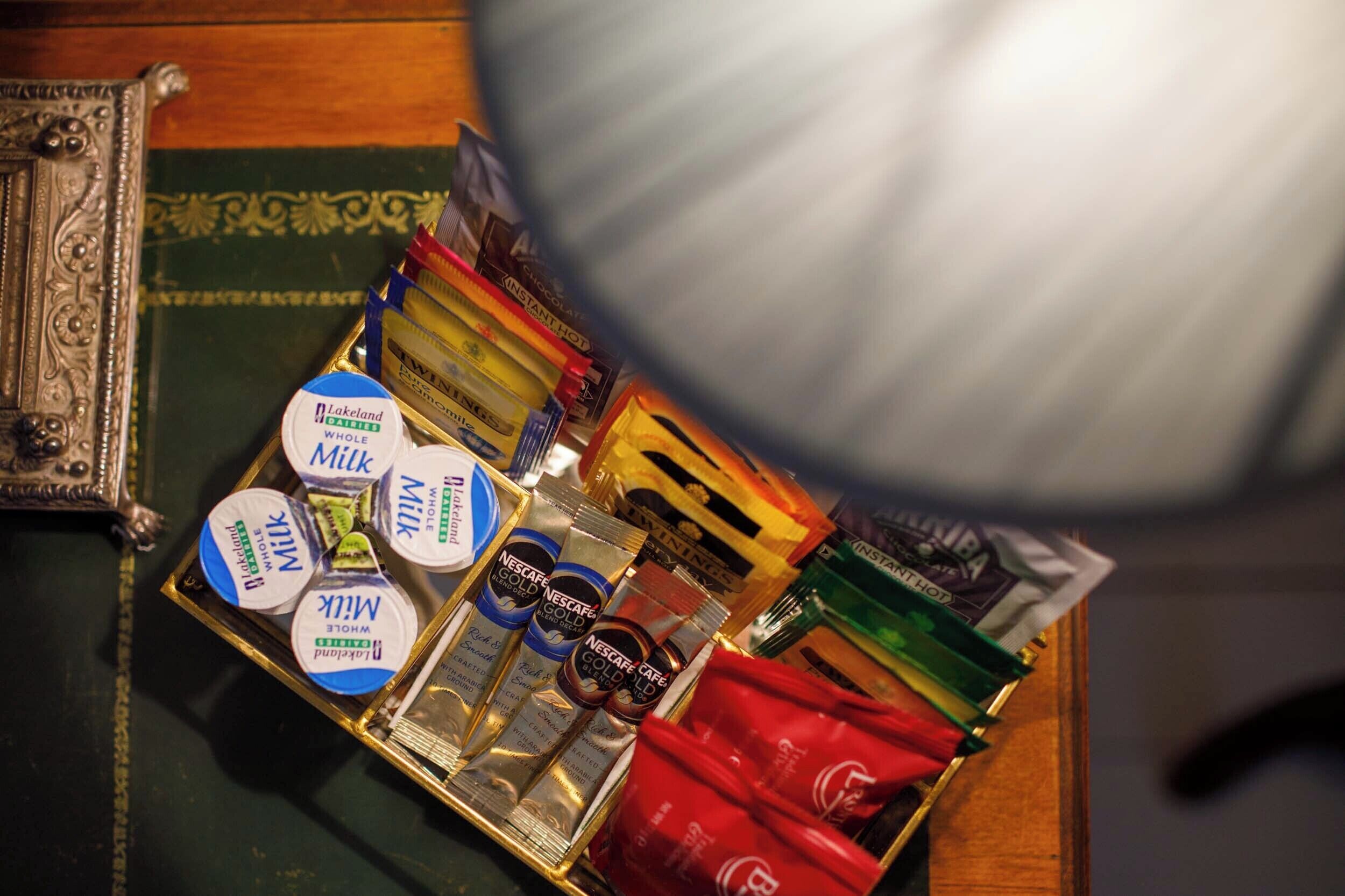 Ein Tablett mit verschiedenen Speisen, darunter Nescafé Gold, Lakeland Vollmilch und Instantnudeln.