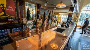 A bar with copper tap handles, a sign reading "Fursy Fergret," and a "Seedors Gold" beer tap. - The Duchess of Cornwall Inn (Dorchester)