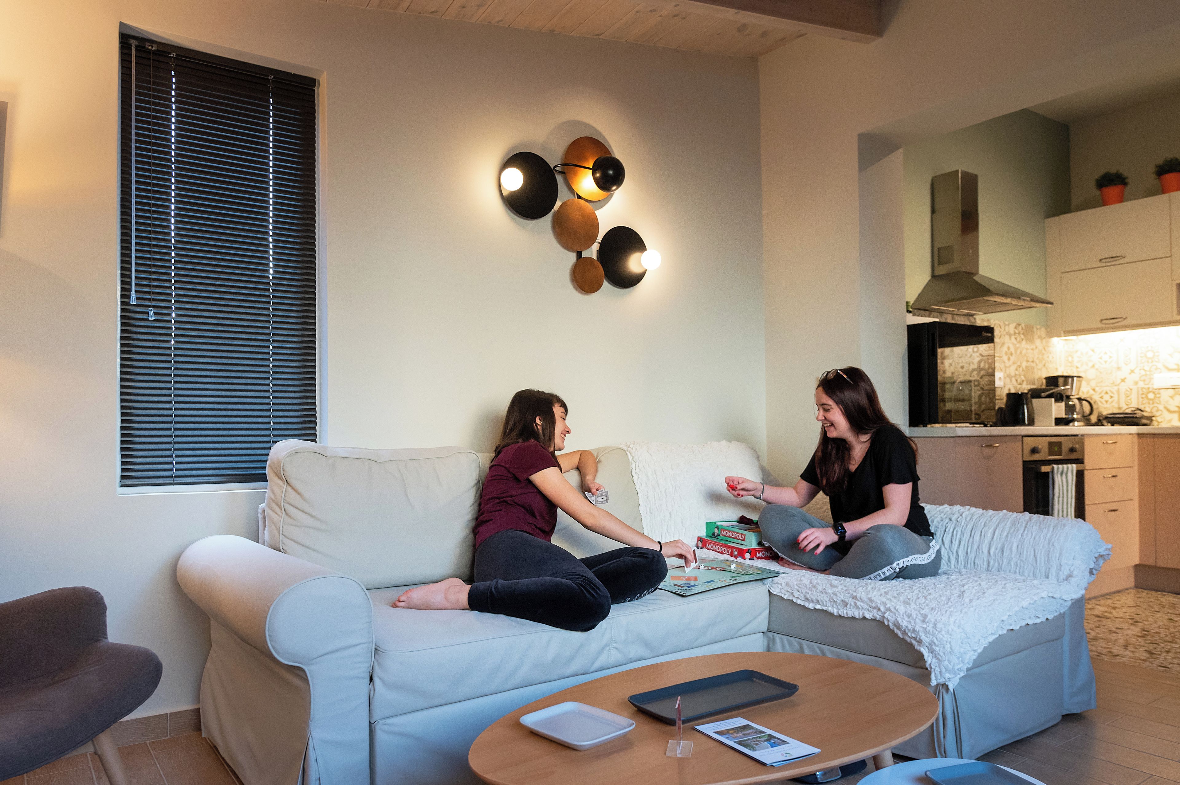Un salon moderne avec un canapé, une table basse et un coin cuisine à l’arrière-plan.