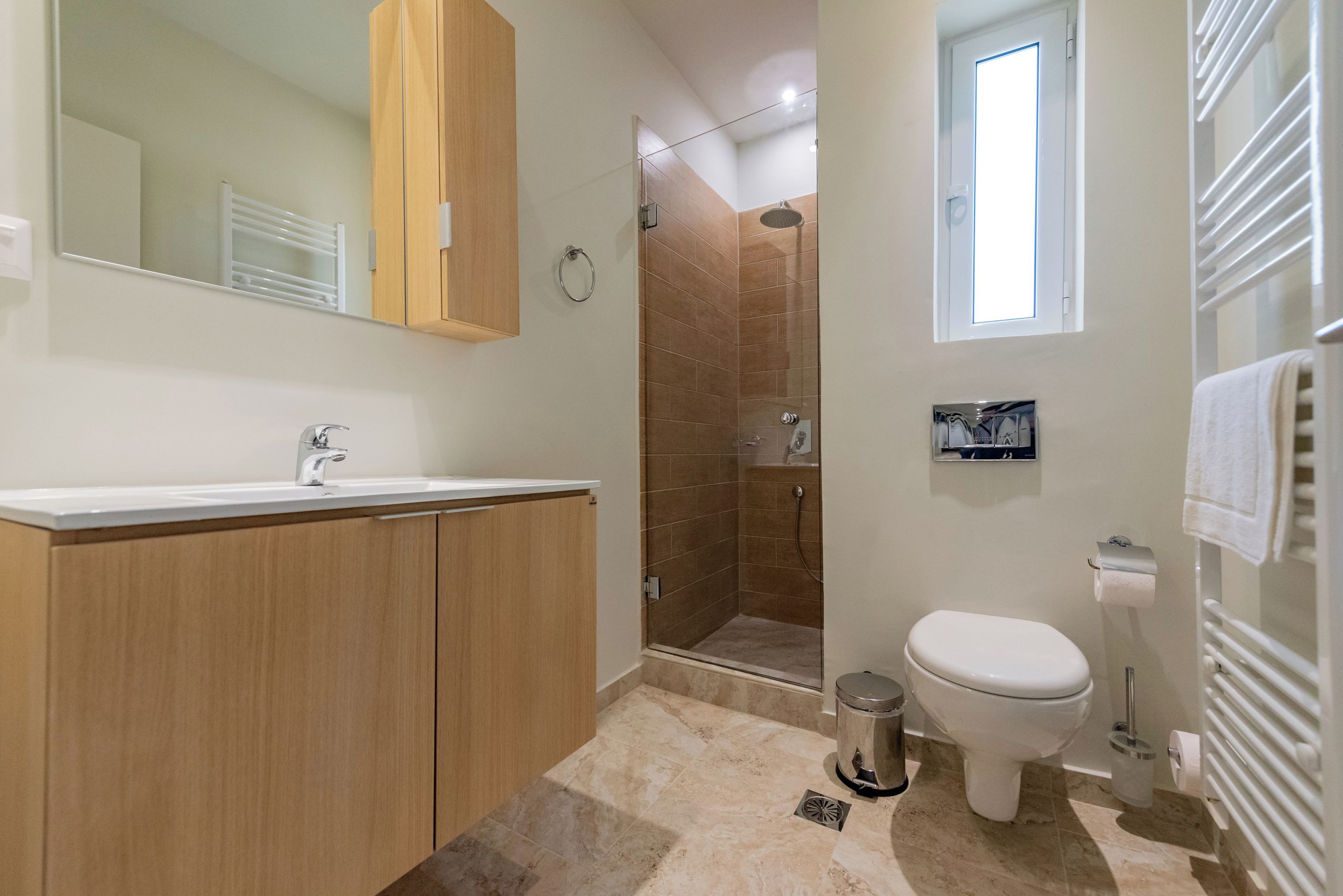 A modern bathroom with a shower, toilet, and sink.