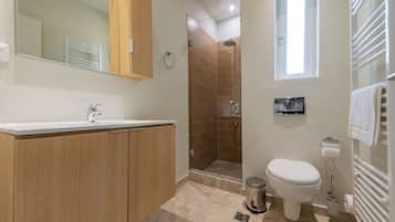 A modern bathroom with a shower, toilet, and sink.