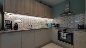 Una cocina con armarios de madera, una campana extractora de acero inoxidable y un salpicadero con diseño.