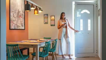 A dining area with a table, chairs, and a person standing by the door.