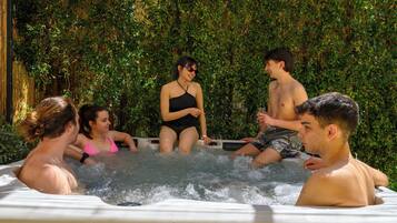 Un groupe de personnes dans un jacuzzi, entouré d’une végétation luxuriante.