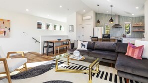 Una sala moderna con sofá, mesa de centro y comedor.