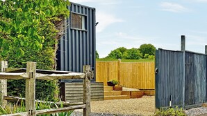 A rustic wooden fence, a metal building, and a gravel path. - 1 bedroom accommodation in East Ilsley (East Ilsley)