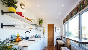 A modern kitchen with a wooden bench, a washing machine, and a large window. - 1 bedroom accommodation in East Ilsley (East Ilsley)