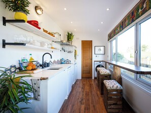 Une cuisine moderne avec un banc en bois, un lave-linge et une grande fenêtre.