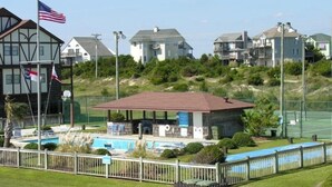 Una propiedad frente a la playa con piscina, un área de estar techada y un asta con la bandera estadounidense.