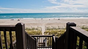 A beach with a wooden walkway leading to the shore. - Ocean Reef 4-B2, Oceanfront Condo in Emerald Isle, NC! (Emerald Isle)