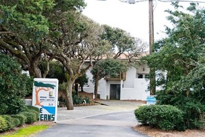 entrance to a serene residential haven, surrounded by mature trees and beautifully maintained gardens.