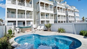 A hotel with a pool area, multiple balconies, and a wooden deck. - Palm Cottage I At The Grove, Oceanfront House in Atlantic Beach, NC! (Atlantic Beach)