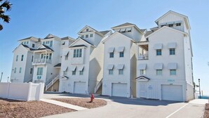 A row of white beachfront condominiums with multiple garage doors and balconies. - Palm Cottage I At The Grove, Oceanfront House in Atlantic Beach, NC! (Atlantic Beach)