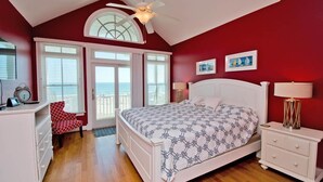 A bedroom with a bed, a desk, a chair, a nightstand, and a ceiling fan. - Palm Cottage III At The Grove, Oceanfront House in Atlantic Beach, NC! (Atlantic Beach)