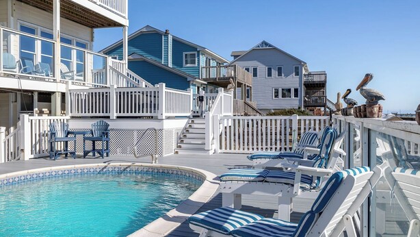 A pool area with lounge chairs and a staircase leading to upper decks. - Pelican Perch, Oceanfront House in Emerald Isle, NC! (Emerald Isle)
