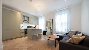 A modern apartment with a kitchen, dining area, and living room. - The Battersea Scenery - Elegant 2bdr Flat (London)