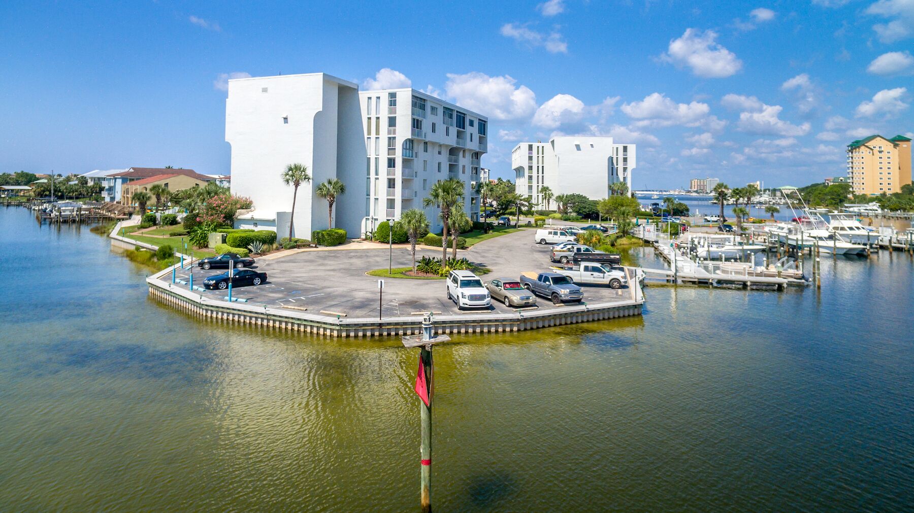 A waterfront hotel with a parking area, a marina, and a view of the water.