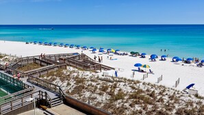 A beach with a wooden boardwalk leading to the shore, clear turquoise waters, and white sand. - HSR 402 is a Luxury 2 BR - Completely Renovated and stunning in its decor (Destin)