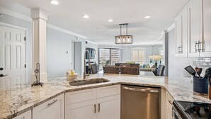 Una cocina moderna con una isla central, electrodomésticos integrados y una zona de comedor con vistas.