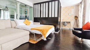 Ein modernes Schlafzimmer mit Bett, Sofa, Schreibtisch und Stuhl.