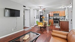 Un salon moderne avec une table basse en verre, un canapé en cuir et un coin repas comprenant une table et des chaises.