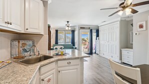 A kitchen with white cabinets, a granite countertop, and a ceiling fan. - SPC8245 - Studio with Murphy bed and some upgrades - Sleeps 4 (Destin)