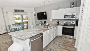 A modern kitchen with white cabinetry, a built-in microwave, and a stainless steel oven.