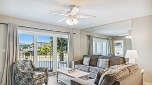 A spacious living room with a sofa, armchair, and coffee table. - ⛱️SeaCrest 211 - Beachfront Complex without Beachfront Prices! (Fort Walton Beach)