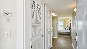 Um corredor com portas brancas, uma cama com vista e uma placa indicando a sala 701A.