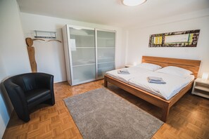 Cozy retreat with a comfortable bed, stylish chair, and ample storage.