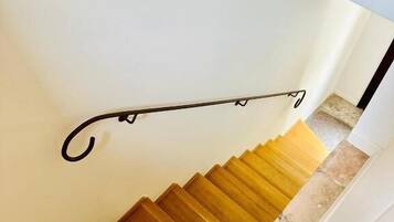 Una escalera de madera con barandilla metálica.
