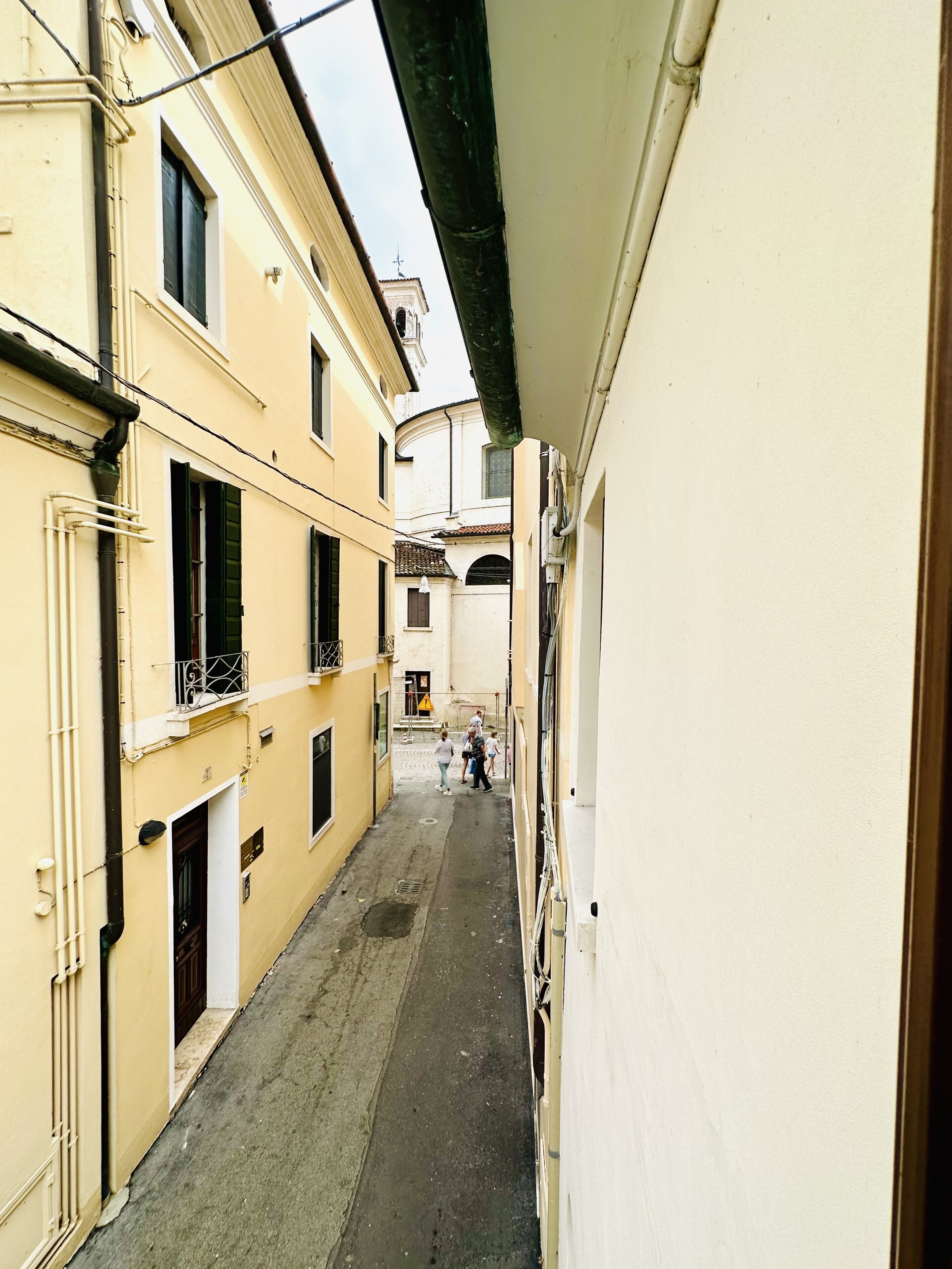 Un callejón estrecho entre edificios, con cielo despejado arriba.