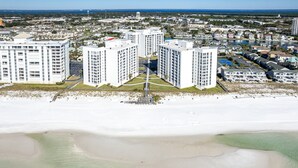 A high-rise hotel with a central courtyard, located near a beach with a view of the ocean and a marina. - Shoreline Towers 1052 - Beautiful 2 BR with Gulf views (Destin)
